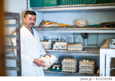 Man packing hen eggs in farmhouse. Man packing hen eggs in farmhouse. 61320288