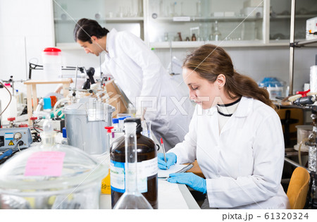 Female scientist taking notes in test chart Female scientist taking notes in test chart 61320324