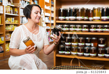 Woman choosing honey in store Woman choosing honey in store 61320843