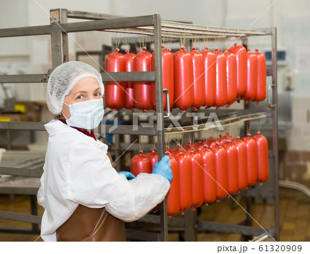 Female carrying sausages on racks 61320909