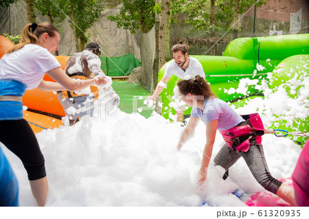 Game of funny friends in soap suds on an inflatable trampoline 61320935