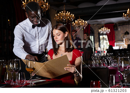 African-american waiter receiving order from guest in fashionable restaurant African-american waiter receiving order from guest in fashionable restaurant 61321203