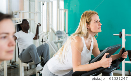Man and women exercising on simulators Man and women exercising on simulators 61321247