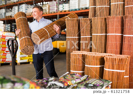 Man buying braided wooden fence 61321758