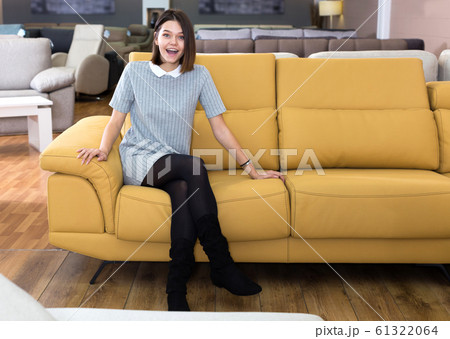 Woman testing sofa in furniture store 61322064