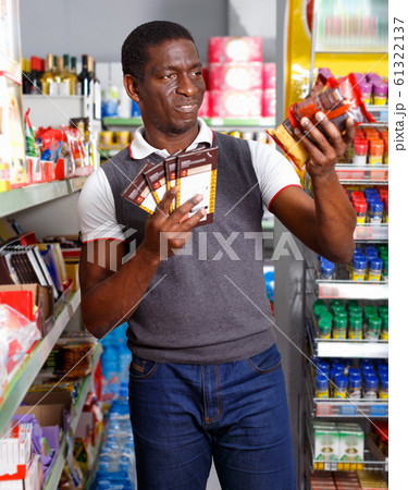 Portrait of Afro man buying chocolate sweets in store Portrait of Afro man buying chocolate sweets in store 61322137
