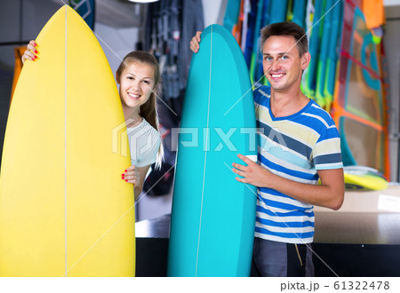 couple is demonstraiting surfboard in nautical shop. couple is demonstraiting surfboard in nautical shop. 61322478