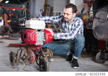 Professional worker is starting to work with plough Professional worker is starting to work with plough 61322530