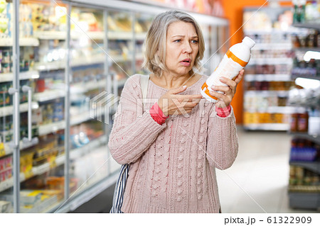 Shocked ordinary female reading product label 61322909