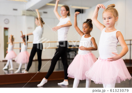 Dance teacher helping her little girls students Dance teacher helping her little girls students 61323079