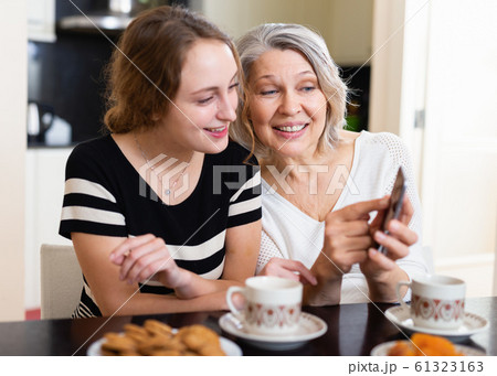 Mother with daughter using smartphone 61323163