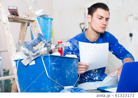 Serious builder with papers and laptop 61323172