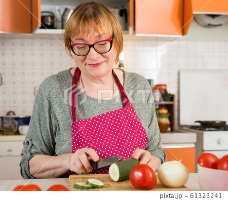Mature housewife cutting vegetables for salad 61323241