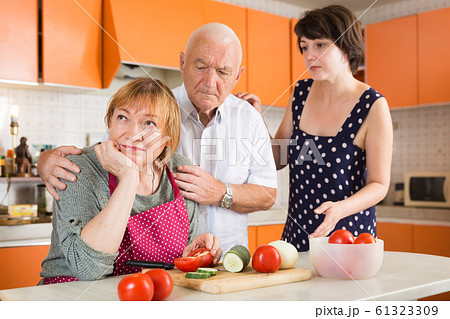 Daughter and husband calming upset aged woman Daughter and husband calming upset aged woman 61323309