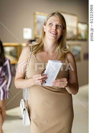 Woman with booklet looking at exhibits Woman with booklet looking at exhibits 61323966