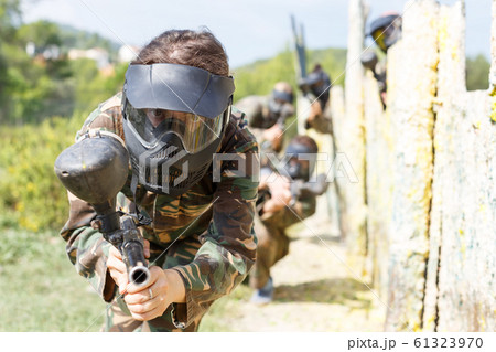 Female paintball player aiming in shootout 61323970