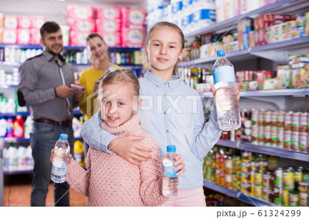 Two sisters holding bottled water Two sisters holding bottled water 61324299