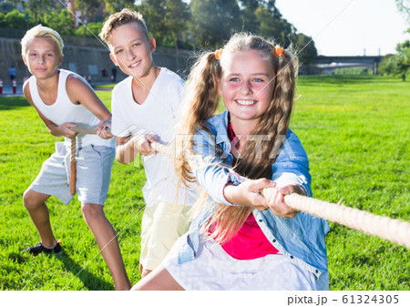 Children playing tug of war outdoors Children playing tug of war outdoors 61324305