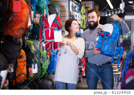 Couple choosing rucksack in store Couple choosing rucksack in store 61324450