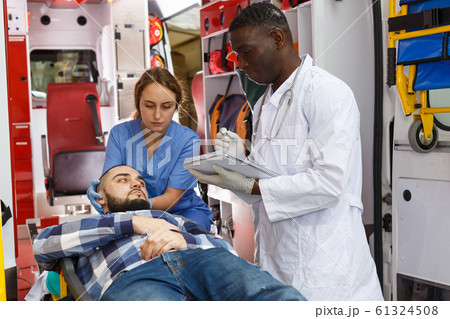 Doctor asking patient to sign in logbook Doctor asking patient to sign in logbook 61324508