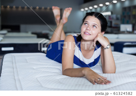 Portrait of cute female lying on soft mattress 61324582
