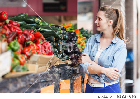 Woman is choosing fresh aubergine Woman is choosing fresh aubergine 61324668