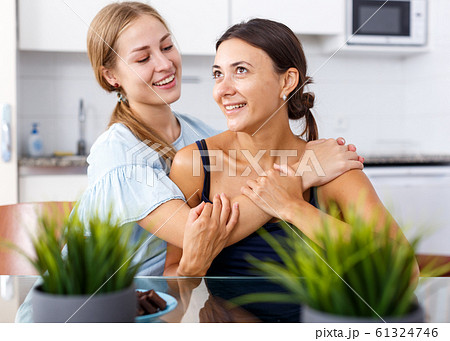 Young happy girlfriends hugging and having fun together at table Young happy girlfriends hugging and having fun together at table 61324746