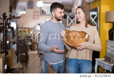 Happy couple choosing vintage wooden platter 61324845