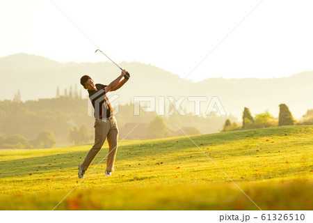 Professional Golfer asian man swing and hitting golf ball practice at golf driving range 61326510