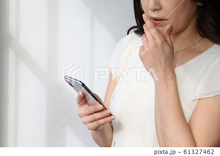 迷惑メール・電話詐欺に不安になる女性 61327462