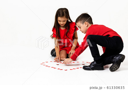 couple girl and boy make big heart shape out of small paper hearts 61330635