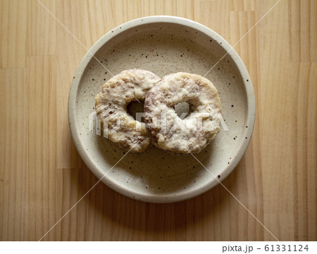 白い陶器のお皿の上に重なった2つのドーナツ 俯瞰 右上 白い陶器のお皿の上に重なった2つのドーナツ 俯瞰 右上 61331124