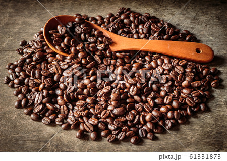 Coffee beans in a wooden scoop and on old wooden Coffee beans in a wooden scoop and on old wooden 61331873