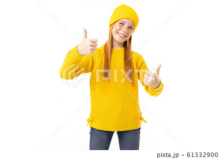 Happy teenager girl with red hair, yellow hoody and trousers shows like isolated on white background Happy teenager girl with red hair, yellow hoody and trousers shows like isolated on white background 61332900