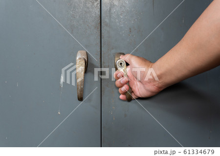 Hand of men is opening old and rusty steel cabinet 61334679