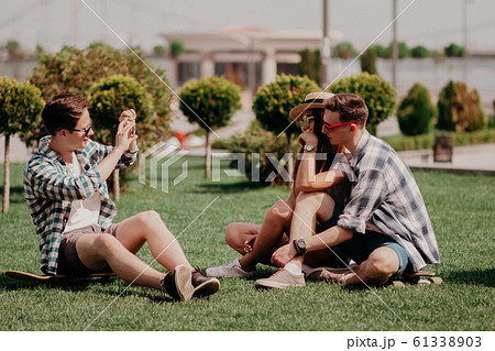 A Guy Is Makng Photo Of His Friends Outdoor. 61338903