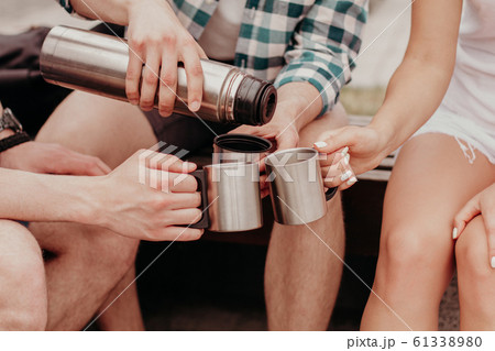 Hand Is Pouring Tea From The Thermos Into Three Mugs. 61338980