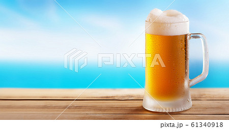 cold mug of beer on a wooden table on background 61340918