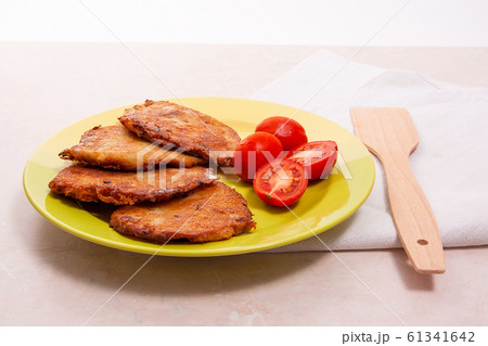 Potato pancakes with meat and tomatoes on green Potato pancakes with meat and tomatoes on green 61341642