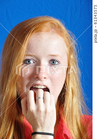 Scared teen on blue background Scared teen on blue background 61343575