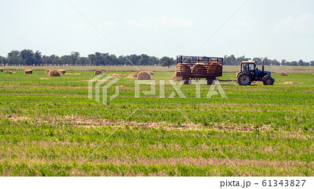 Tractor loading hay bales on truck agricultural works Tractor loading hay bales on truck agricultural works 61343827