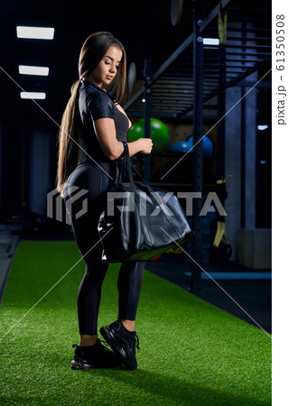 Woman posing with sport bag in gym. 61350508