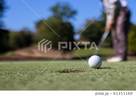 Man playing golf on a golf course. 61351160