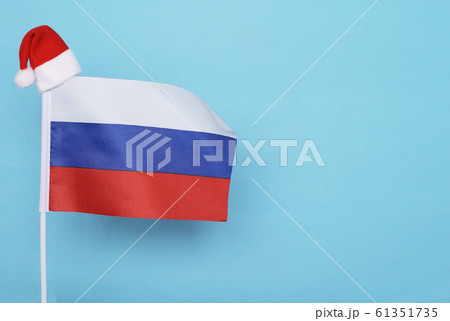 Flag of Russia with little santa claus hat on blue background. New Year winter holiday concept, copy space 61351735