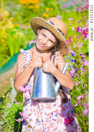girl with metal watering can in summer garden girl with metal watering can in summer garden 61351815