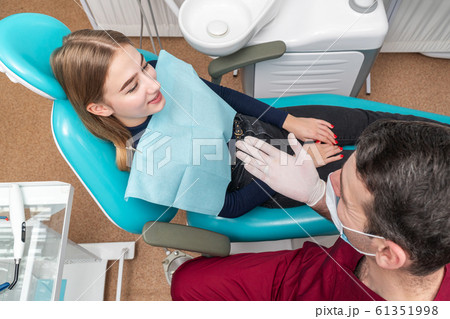 Dentist talking to a patient 61351998