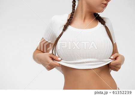 Crop sensual young lady taking off shirt Crop sensual young lady taking off shirt 61352239