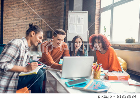 Cheerful students smiling while watching webinar all together Cheerful students smiling while watching webinar all together 61353934