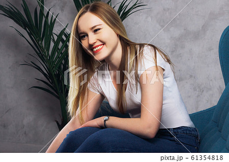 Beautiful girl in a white vest sitting Beautiful girl in a white vest sitting 61354818