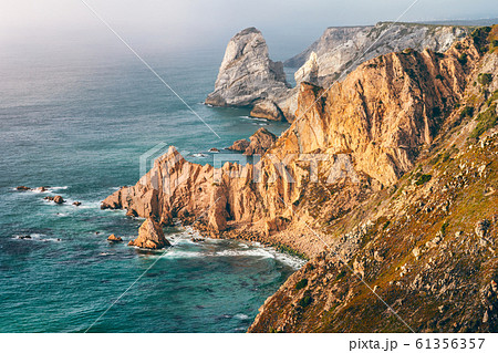 Sintra, Portugal. Rocky coastline between Cape Roca and Praia da Ursa in evening sunset light and Atlantic Ocean 61356357